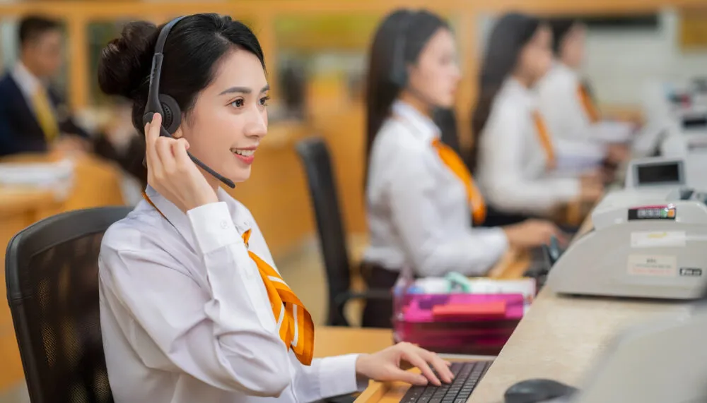 Nhân viên tổng đài đang tiếp nhận cuộc gọi liên hệ Đánh Bài 66 từ khách hàng